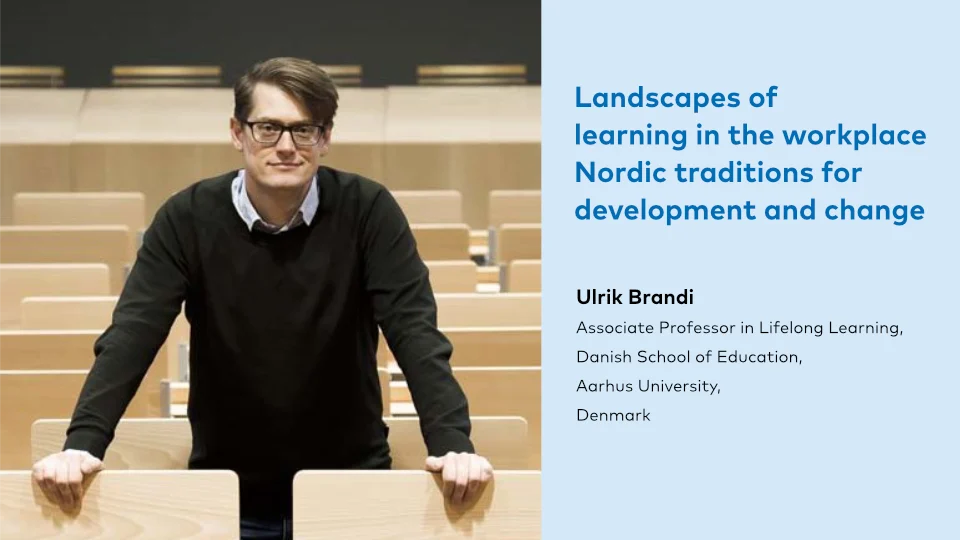 Workplace learning: Need for new competences? keynote Ulrik Brandi A smiling man with glasses and dark hair, dressed in a black sweater over a collared shirt, leans on a lecture hall's wooden desk with rows of empty seats behind him. The text on the right says 'Landscapes of learning in the workplace Nordic traditions for development and change' and beneath, 'Ulrik Brandi, Associate Professor in Lifelong Learning, Danish School of Education, Aarhus University, Denmark'.