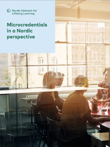 Microcredentials in a Nordic perspective A group of people in a modern office space engaged in a discussion around a red table, with natural light streaming through large windows. The glass reflection adds depth to the scene.