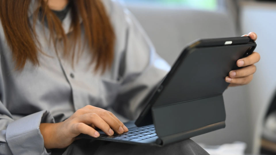Finnish educational system for female prisoners Woman using a tablet with keyboard case while sitting on a couch.