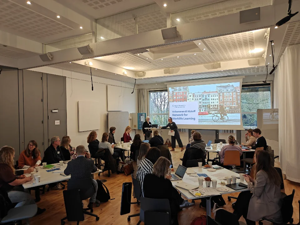 Deltagere ved kickoff-møde for Network for Worklife Learning den 11. november 2025 i København, samlet i mødelokale med præsentation på storskærm.