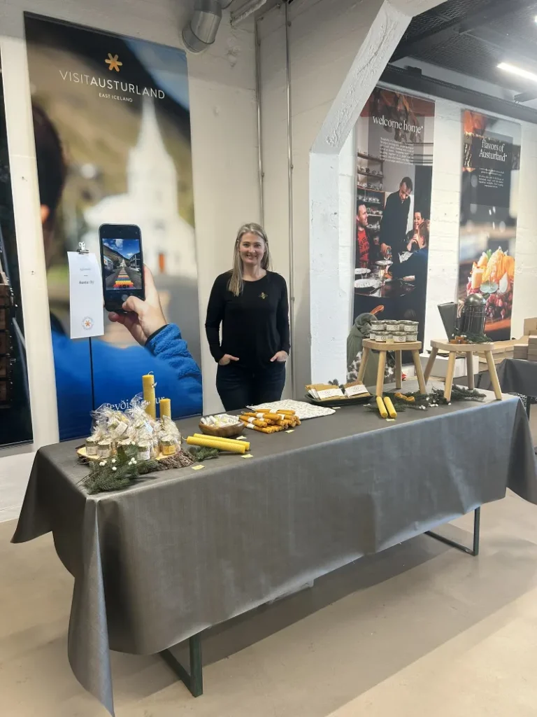 Sæunn Vigdís Sigvaldadóttir står bak et bord med lokale produkter på en messestand for Visit Austurland.
